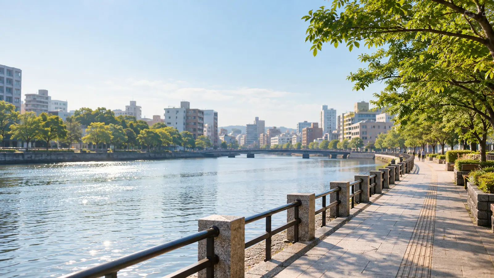 朝の川沿いの遊歩道と街並みのイメージ